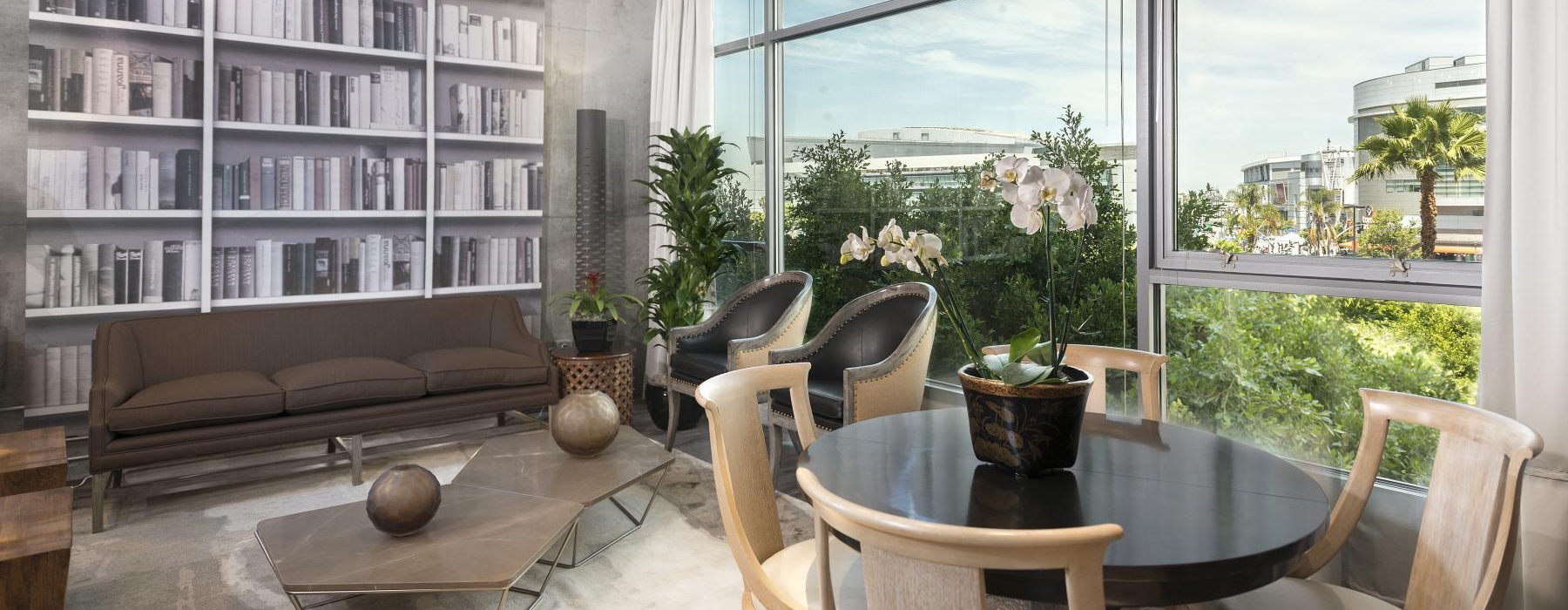 a room with a table chairs and a window with a view of the ocean