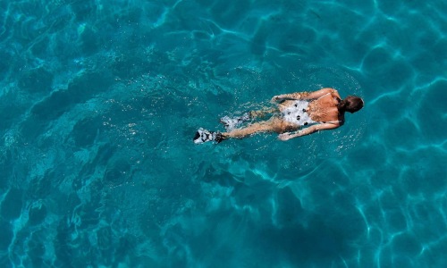 overhead shot of a woman swimming in a pool