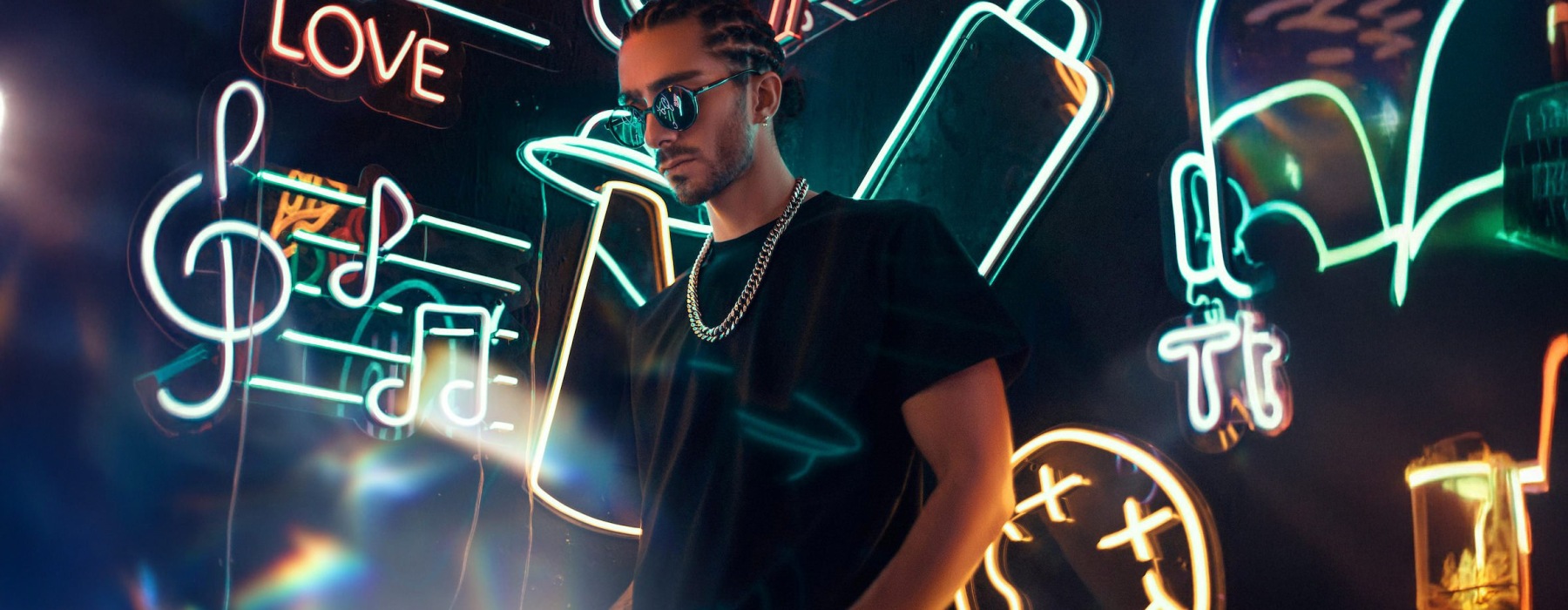 A guy in front of a wall with lights and signs